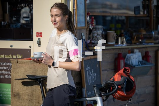 Frau steht an Kiosk mit Kaffee