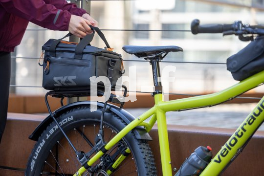 Frau nimmt Fahrradtasche von Gepäckträger