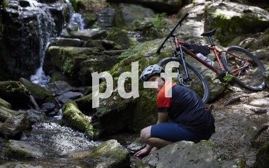Mountainbiker sitzt an Wasser 