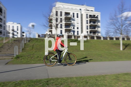 Frau fährt E-Bike in der Stadt