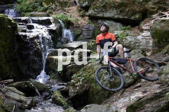 Mountainbiker vor Wasserfall
