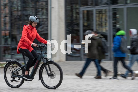 Frau fährt E-Bike in Stadt