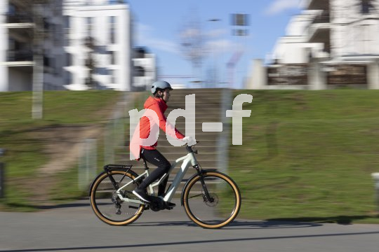 Frau fährt mit E-Bike in der Stadt