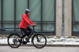 Frau fährt mit E-Bike in Stadt