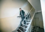 Ein Mann trägt ein E-Bike die Treppe in einem Wohnhaus hinunter.