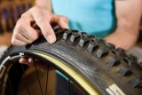 Als nächstes setzt man den Reifen zunächst mit einer Wulst auf die Felge. Hierbei ist zwingend auf die richtige Laufrichtung des Reifens zu achten. Ästheten sorgen für die gleiche Position der Reifenbeschriftung zum Ventil.