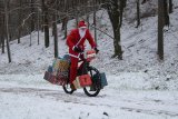 Weihnachtsmann fährt mit Fahrrad durch Winterwald