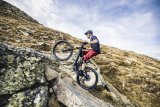 Mann fährt steile Rampen in den Bergen mit E-Mountainbike hoch