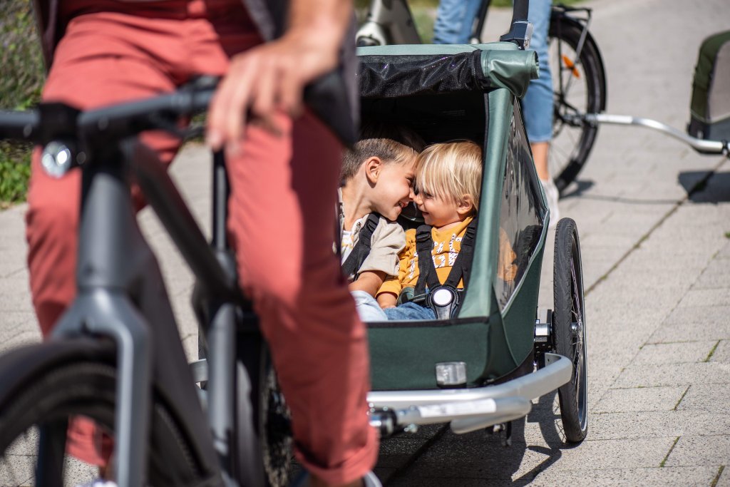 Zwei Kinder in einem Fahrradanhänger.
