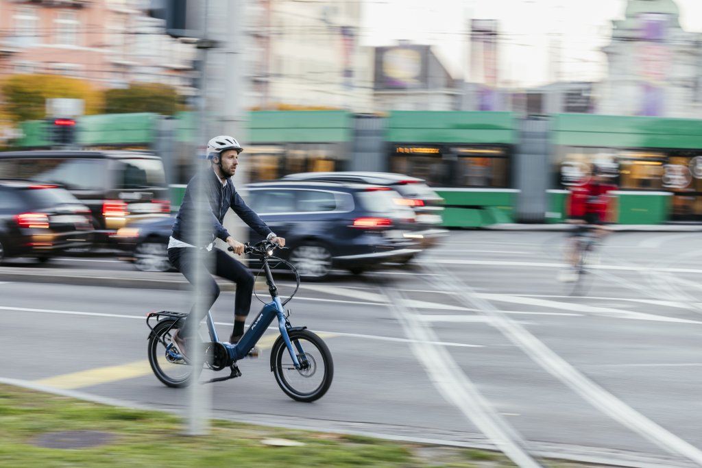Ein Mann fährt auf einem Kompakt-Fahrrad durch die Stadt.
