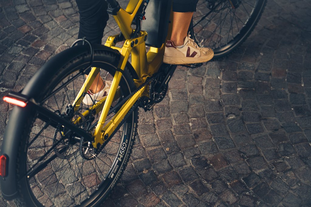 Detailaufnahme des Hinterbaus eines E-Bikes auf der Straße.