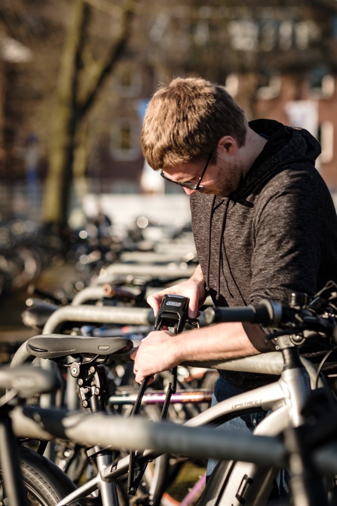 Ein Mann schließt ein E-Bike an einem Fahrradständer an.