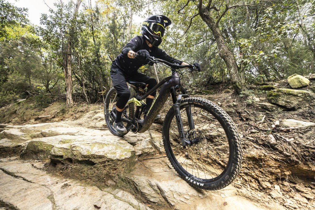 Eine Person mit Vollhelm fährt auf einem E-MTB eine felsige Passage bergab.