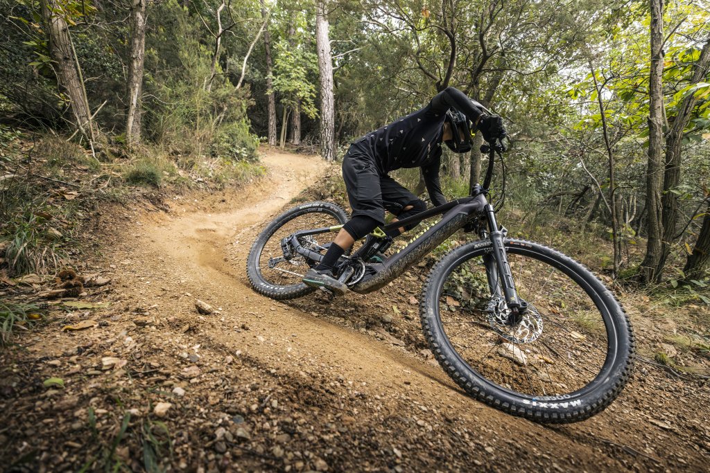 Eine Person fährt auf einem E-MTB auf einer Mountainbike-Strecke um eine Kurve.