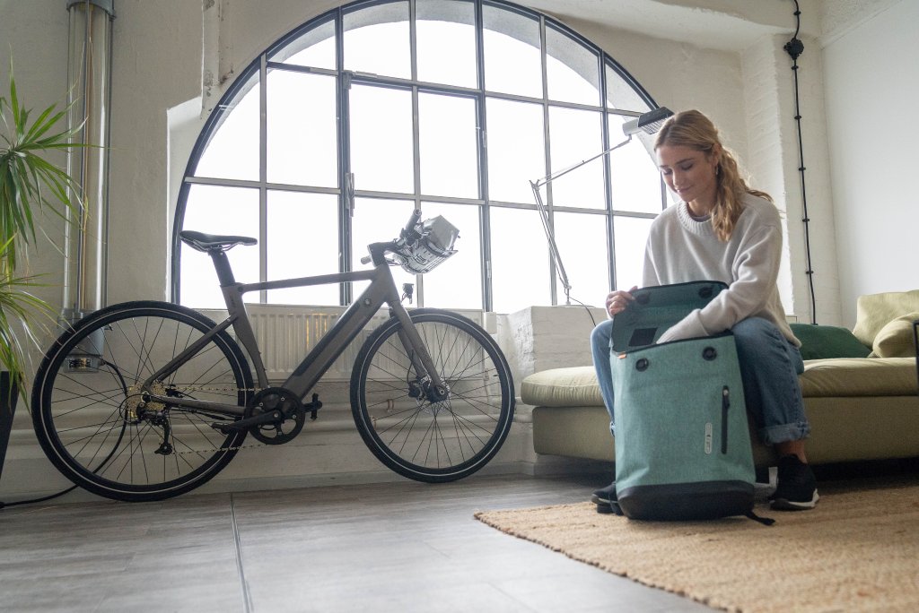 Frau packt Fahrradrucksack in Wohnung