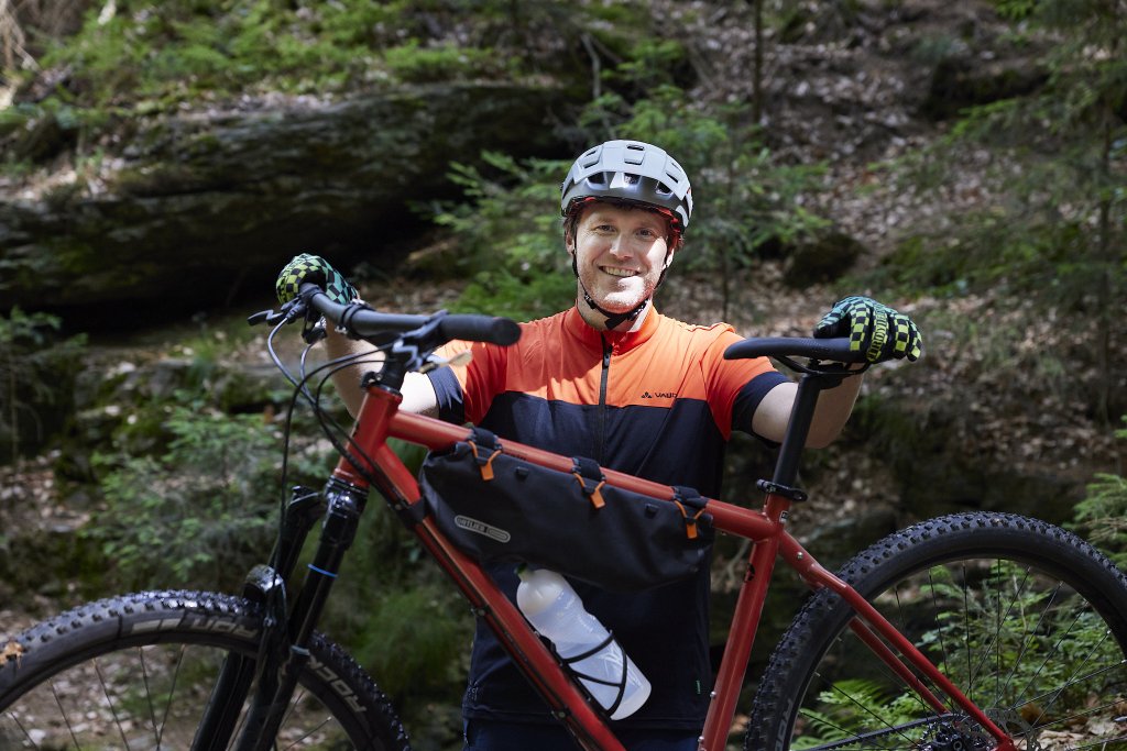 Mountainbiker mit Fahrrad im Wald