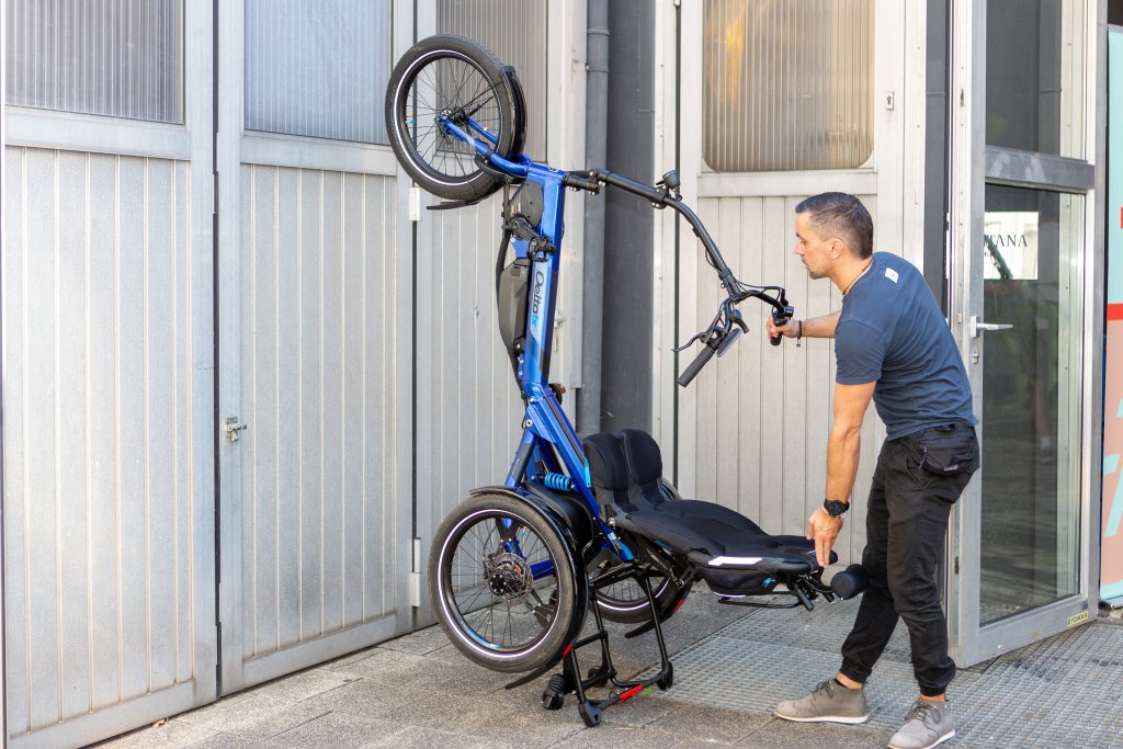 Ein Mann parkt das Sesselrad \\\\\\\"Delta tx\\\\\\\" von HP Velotechnik aufrecht an einer Wand.