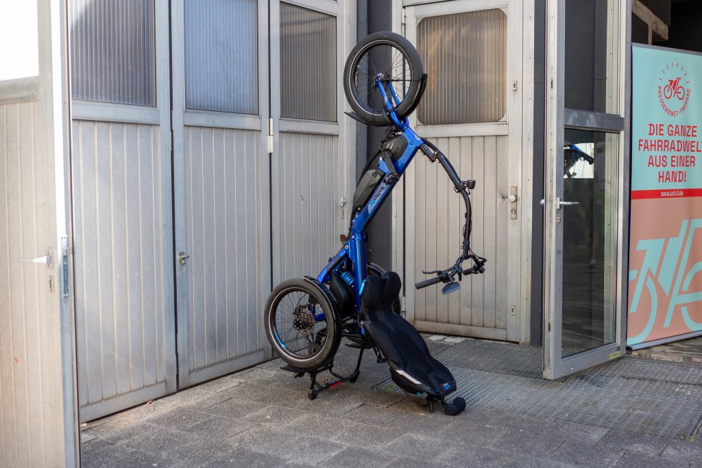 Das Sesselrad \\\\\\\\\\\\\\\"Delta tx\\\\\\\\\\\\\\\" von HP Velotechnik steht aufrecht vor einer Wand.