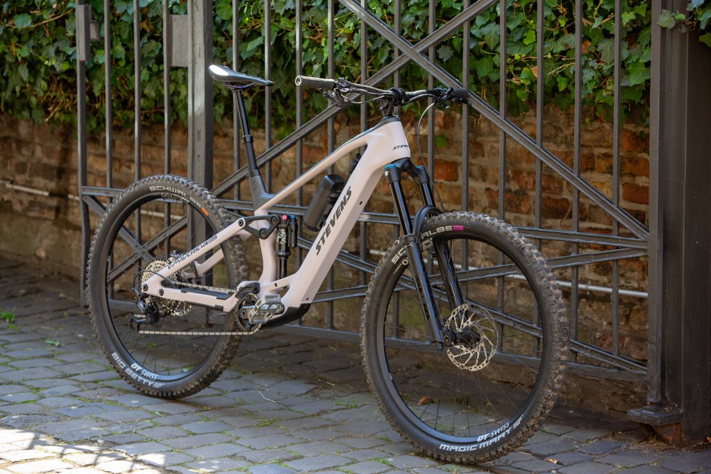 Ein Light-E-Mountainbike mit Zusatz-Akku leht aneinem Zaun.