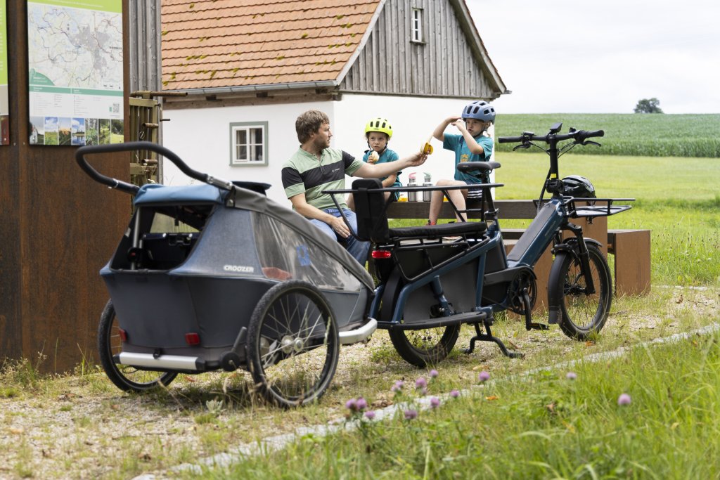 Mann macht mit zwei Kindern Pause bei einer Fahrradtour.