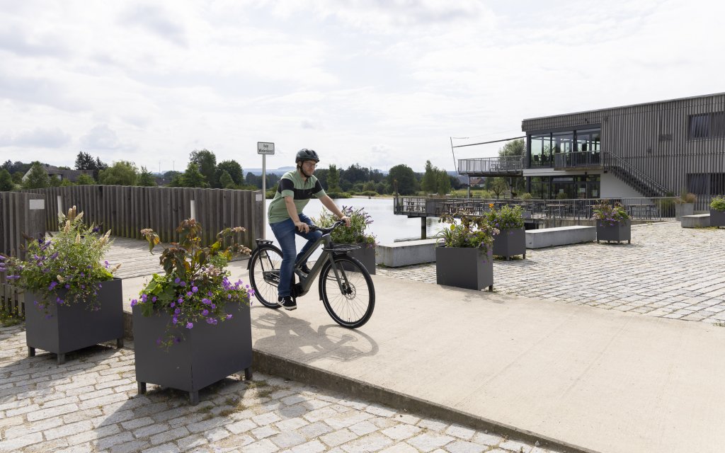 Mann fährt mit E-Bike über eine Brücke.