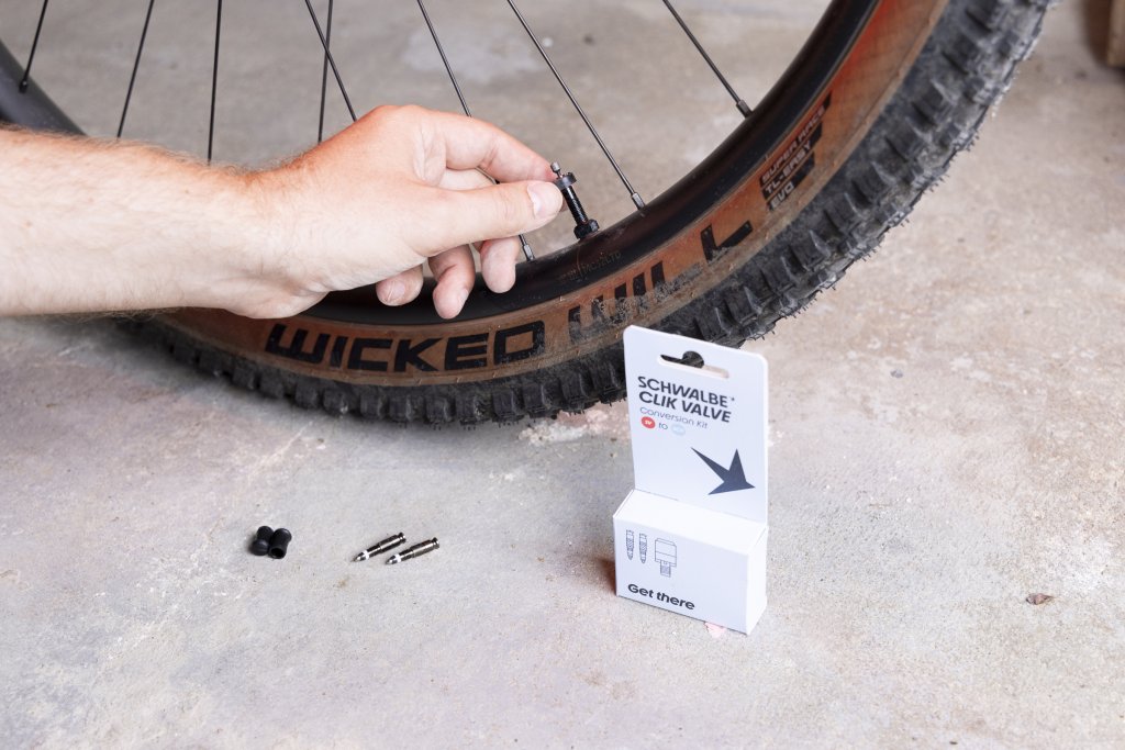 Ventiltausch an einem Mountainbike-Reifen.