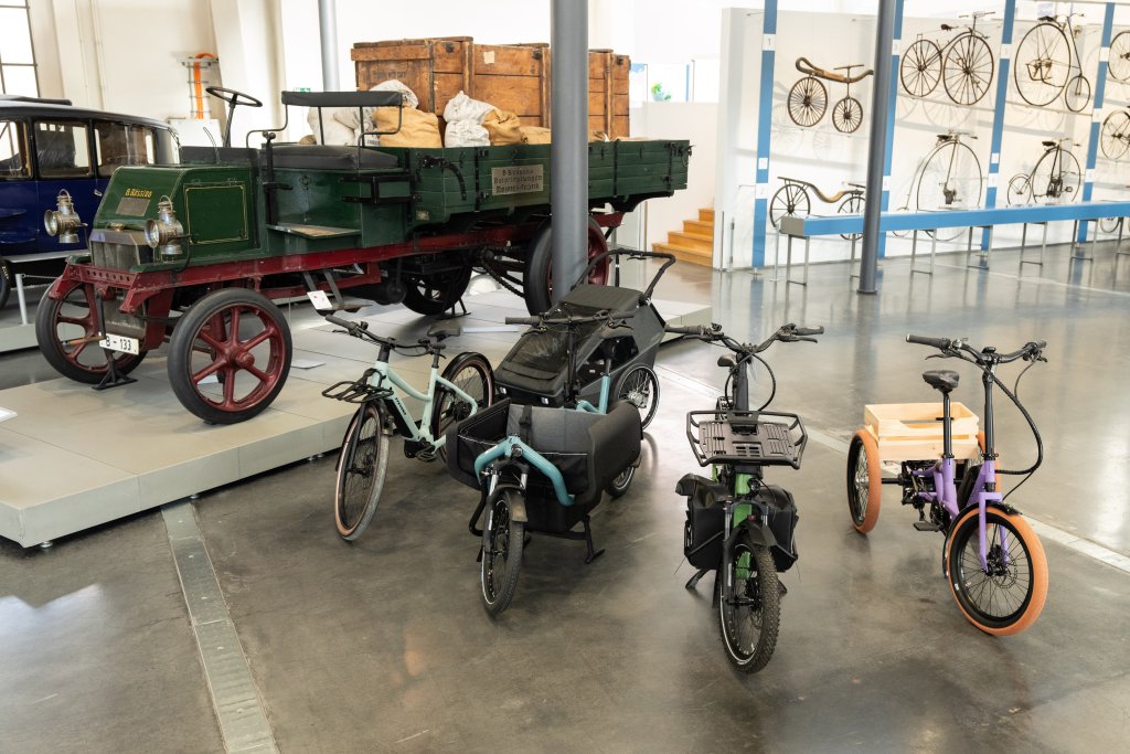 Vier unterschiedliche Cargobikes stehen in einer Halle.