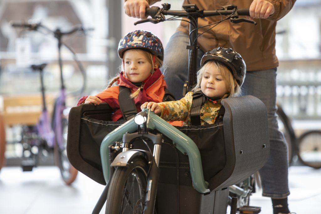 Zwei Kinder sitzen in einem Lastenrad.