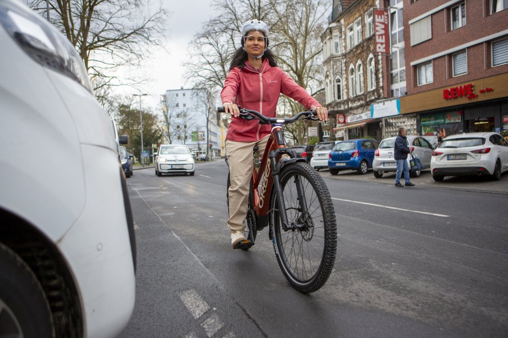 Frau fährt auf einem E-Bike durch die Stadt.