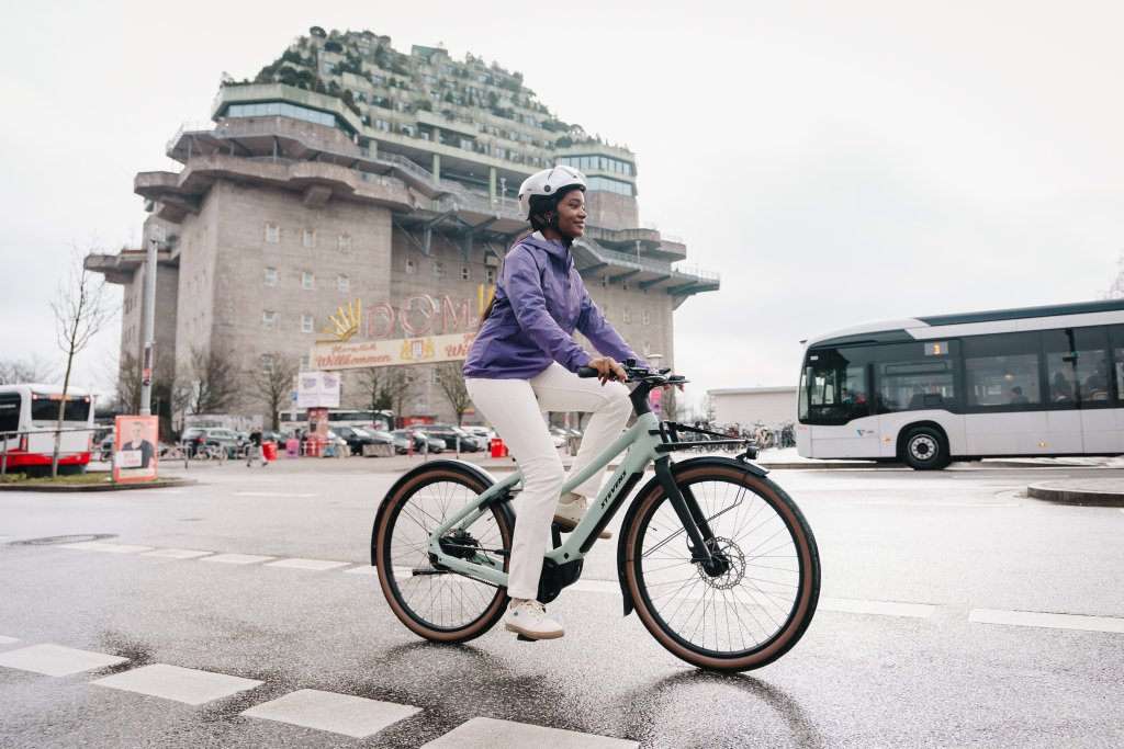 Frau fährt mit einem E-Bike durch die Stadt.