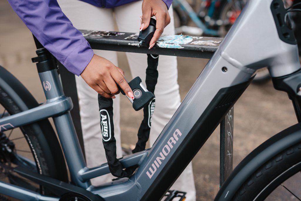 E-Bike wird mit Schloss an Fahrradparker gesichert.
