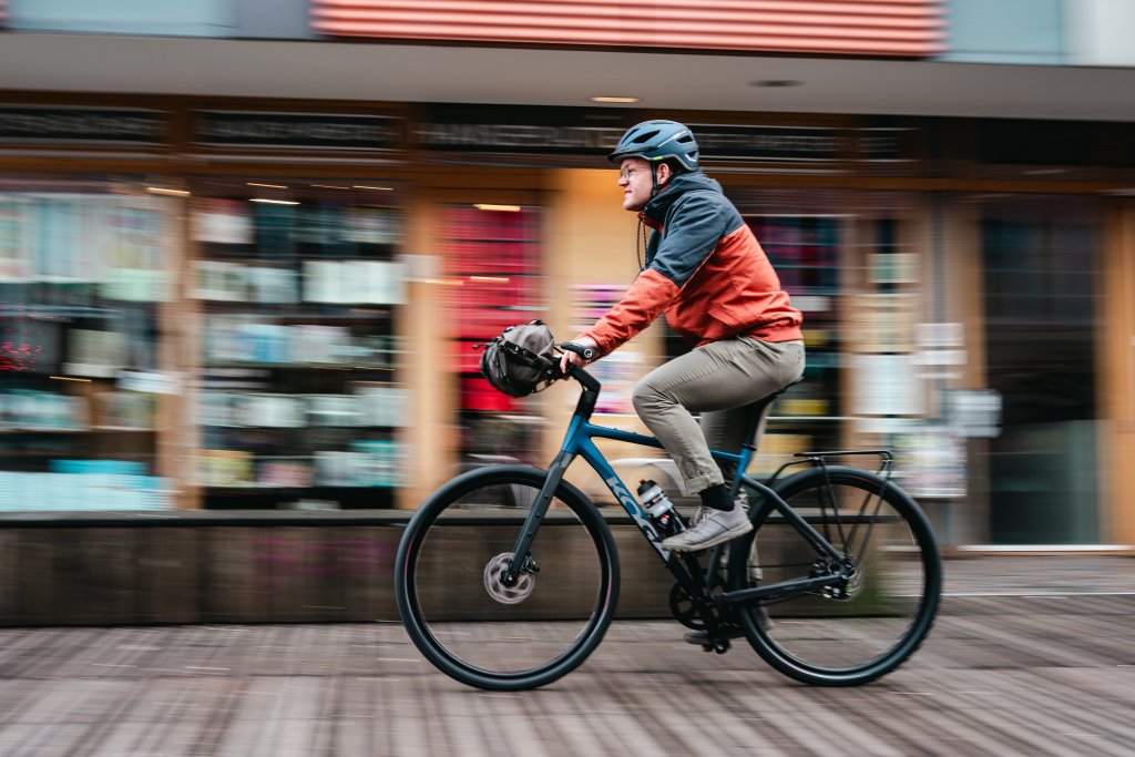 Mann fährt mit Gravelbike durch die Stadt.