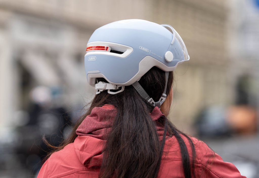 Frau trägt einen Fahrradhelm mit Rücklicht.