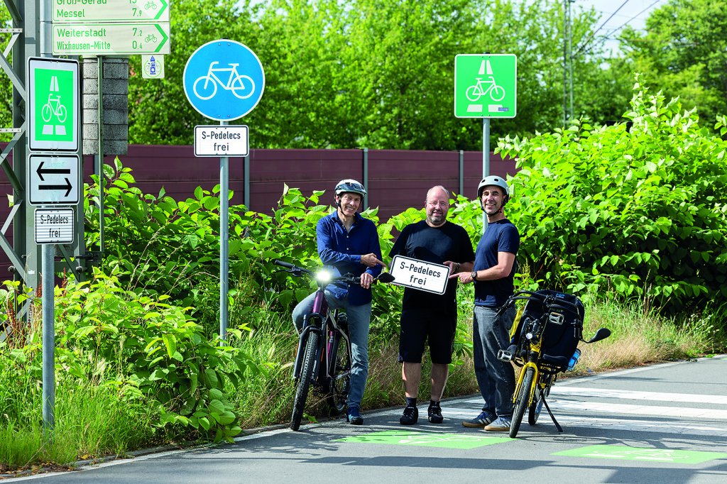 Drei Männer stehen auf einem Radweg. Ein S-Pedelec sowie ein Liege-S-Pedelec stehen dabei.