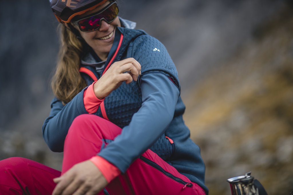 Eine Radfahrerin zeigt das Firmenlogo von Vaude auf dem Ã„rmel ihrer Jacke.