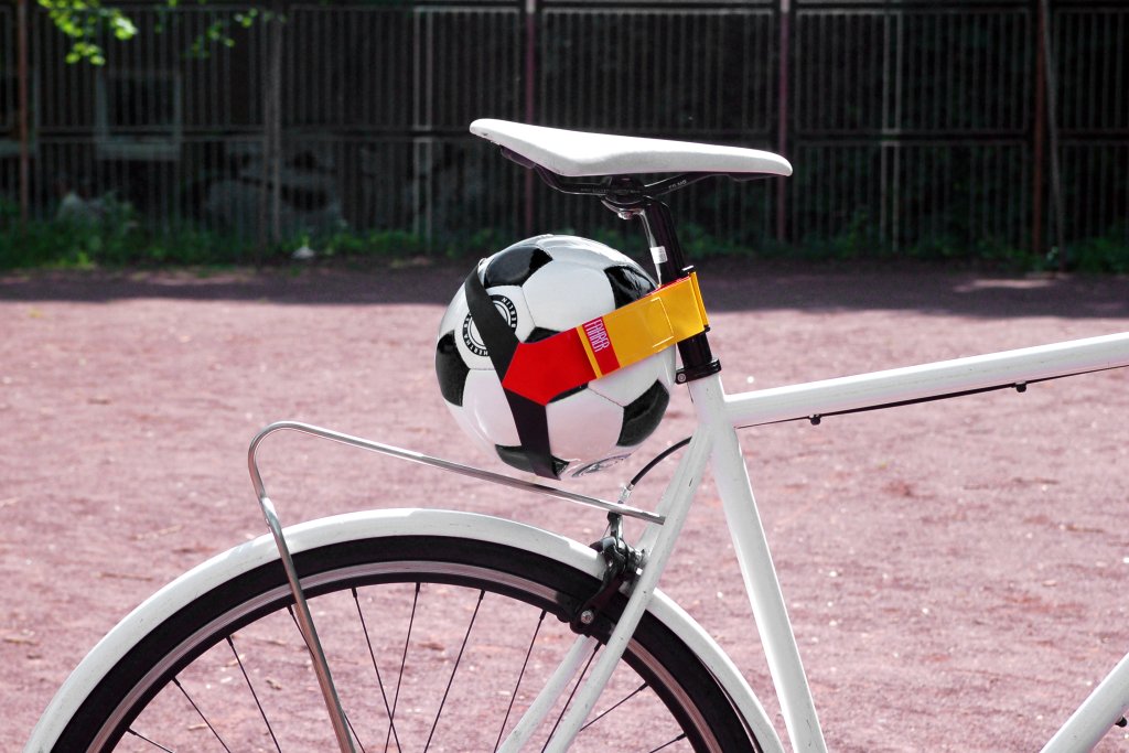 Ein Fußball unter dem Sattel eines Fahrrads befestigt.