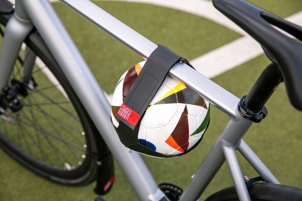 Ein Fußball wurde mit einer Halterung am Fahrrad angebracht.