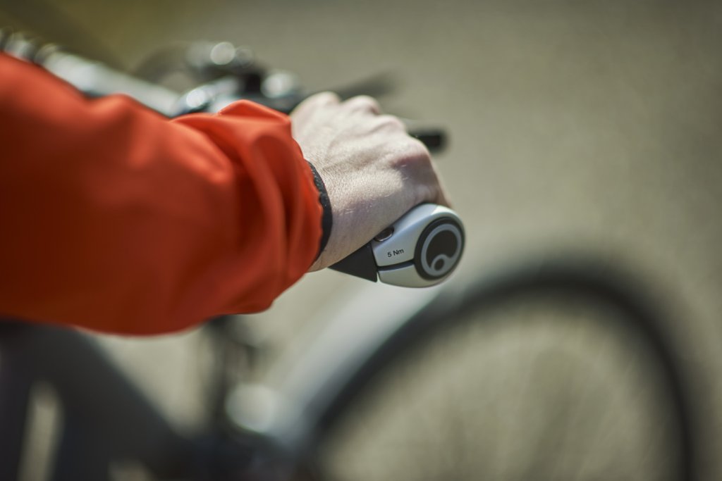 Die Hand einer Rad fahrenden Person am Fahrradlenker.