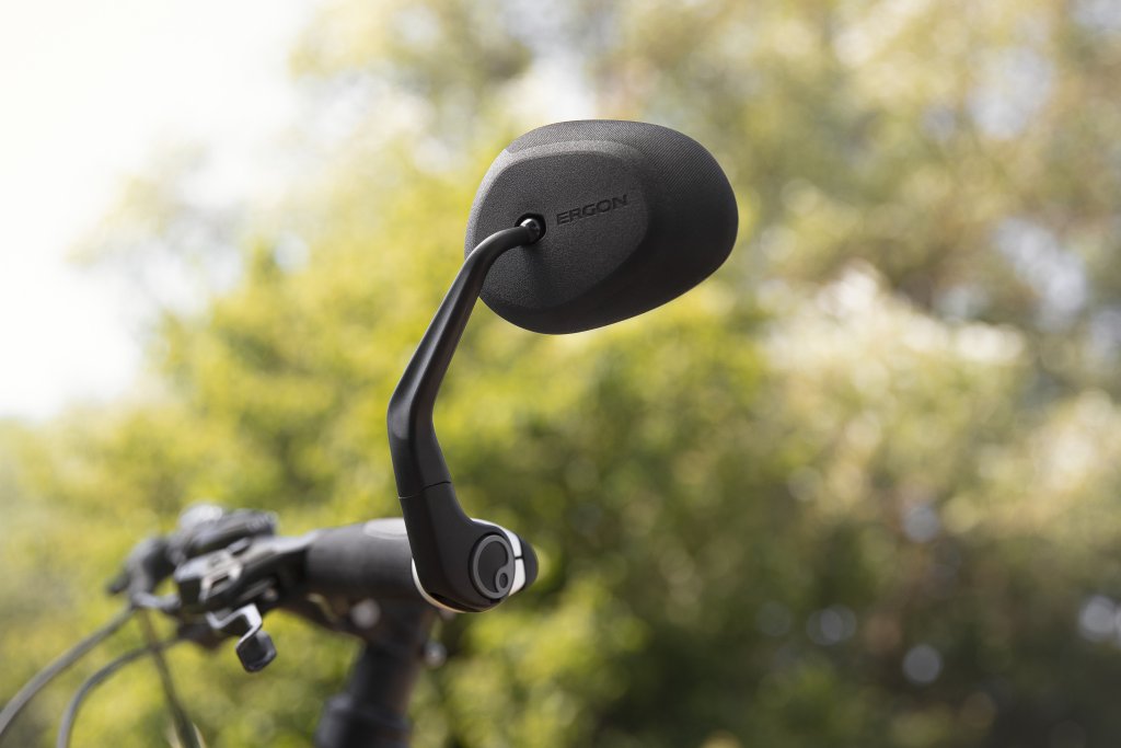 Ein Rückspiegel an einem Haltearm an einem Fahrradlenker