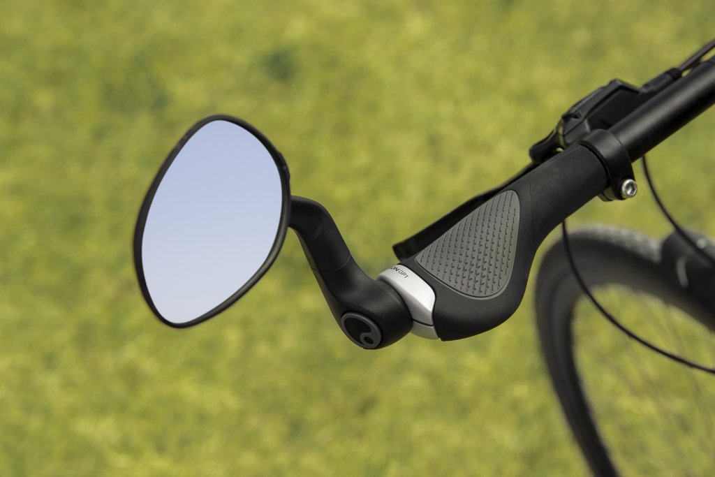 Ein Rückspiegel am linken Ende eines Fahrradlenkers mit ergonomisch geformtem Griff