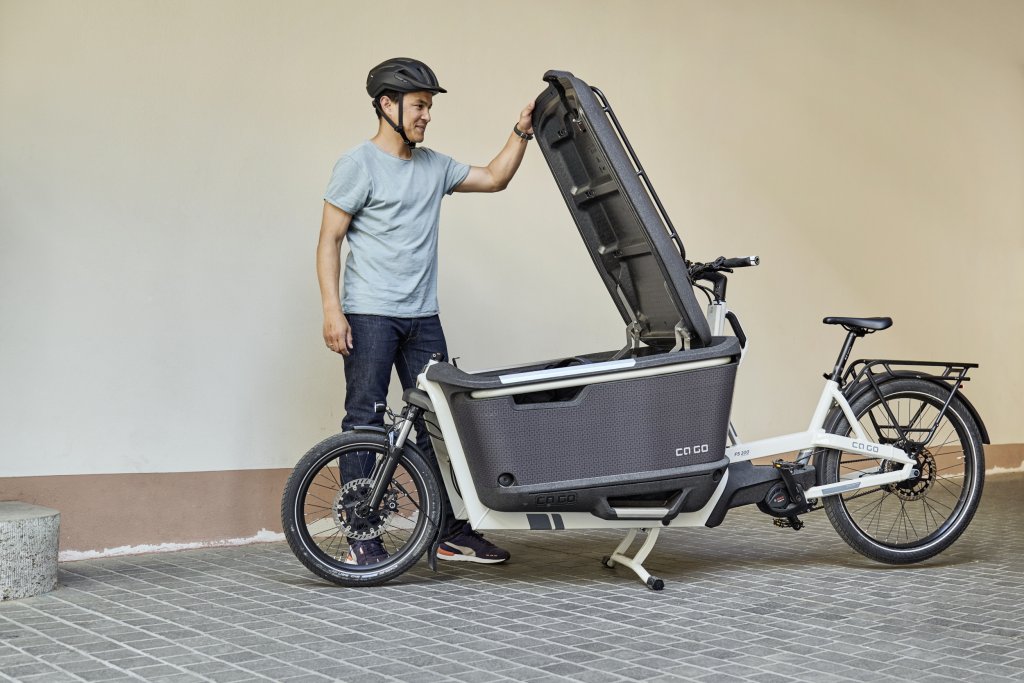 Mann öffnet Box an Lastenrad