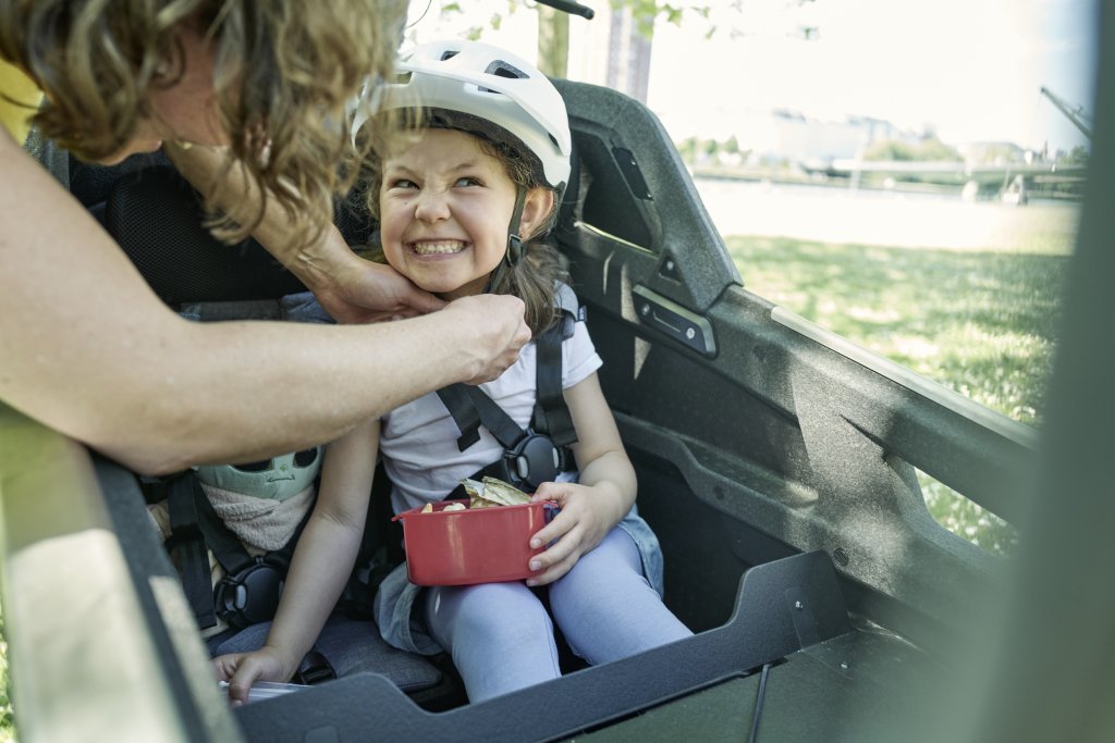 Kind sitzt in Lastenrad 
