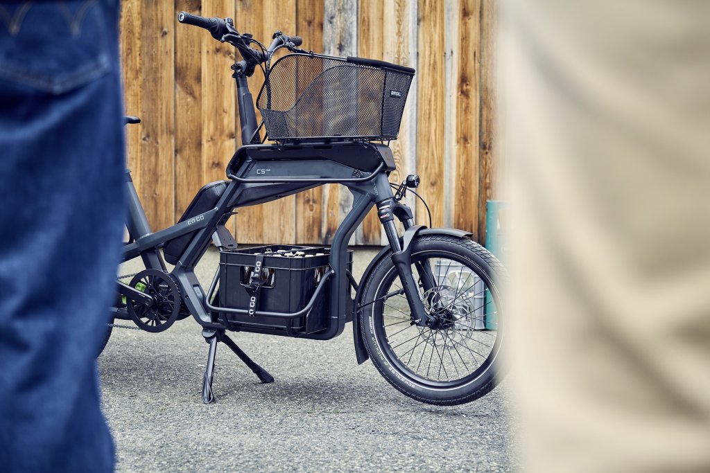 Cargobike steht vor Holzwand.