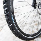 Schnee im Profil eines Fahrradreifens für den Einsatz im Winter.
