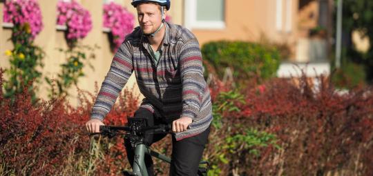 Ein Mann fährt auf einem Fahrrad durch ein Wohngebiet.