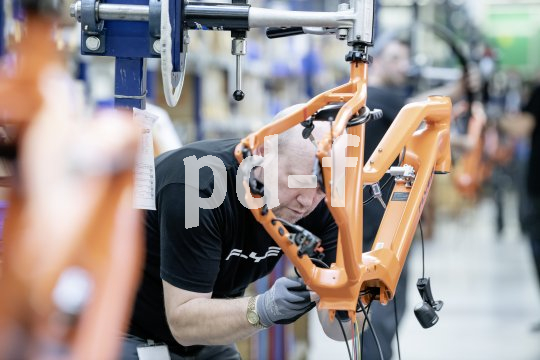 Ein Mann arbeitet an der Montage eines E-Bike-Rahmens.