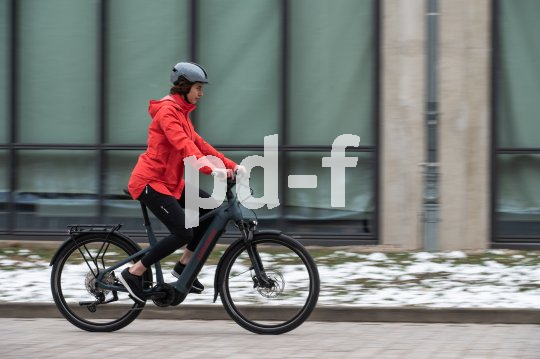 Frau fährt mit E-Bike in Stadt