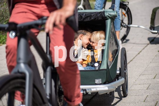 Zwei Kinder in einem Fahrradanhänger.