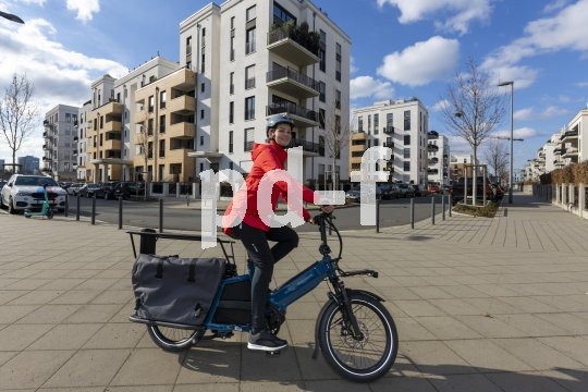 Frau fährt mit Lastenrad in der Stadt