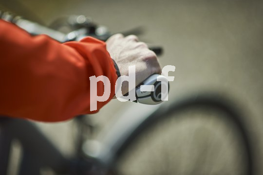 Die Hand einer Rad fahrenden Person am Fahrradlenker.